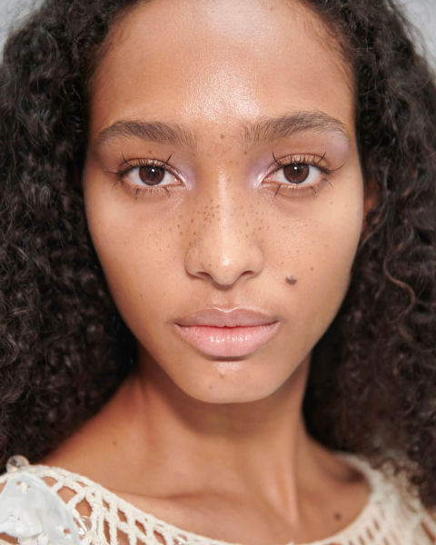 faux freckles on model  summer makeup trends 2025